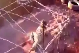 سینه خیز ماهرانه کودک داعشی میان گلوله و سیم خاردار/عکس