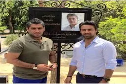 فرهاد و فرزاد مجیدی در زیر تابلوی یادبود حجازی در بهشت زهرا/ عکس