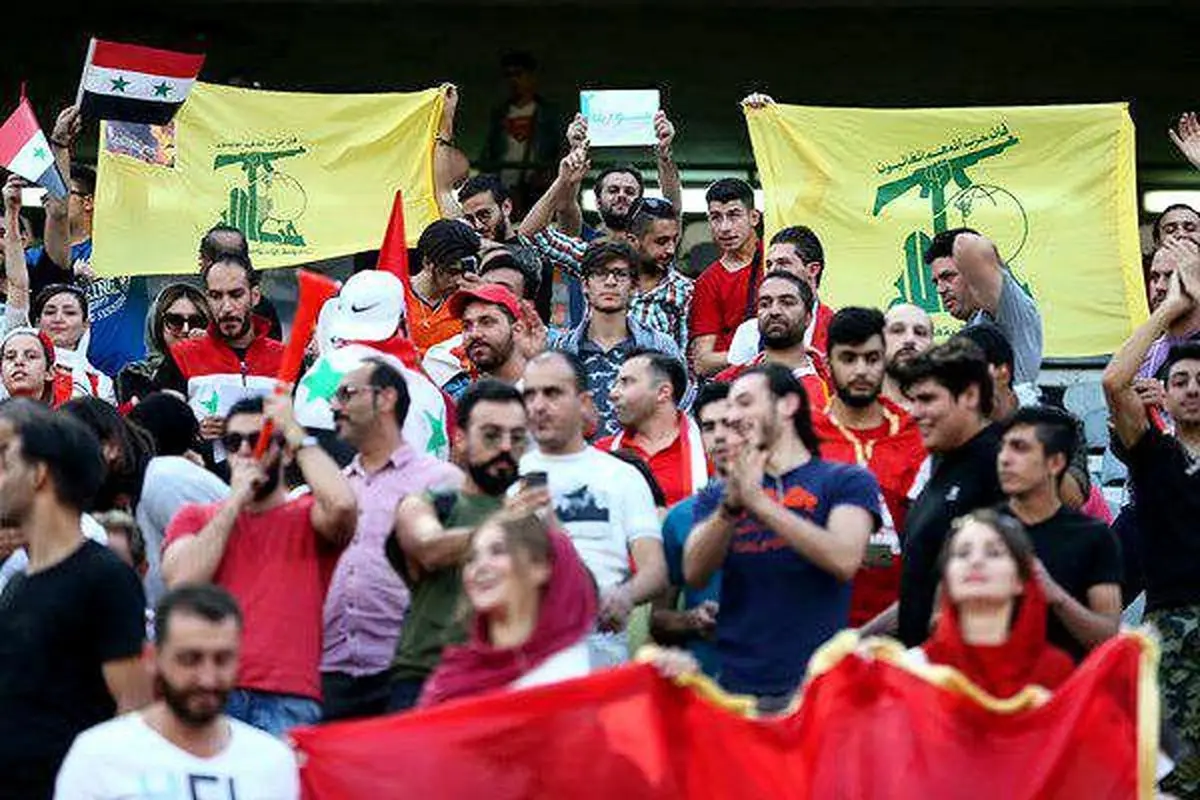 تصویر  پرچم حزب‌الله لبنان در جایگاه تماشاگران سوریه‌ای در ورزشگاه آزادی