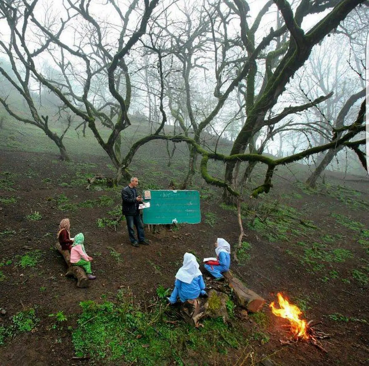 تصویری از یک مدرسه روستایی در جنگل و کنار آتش