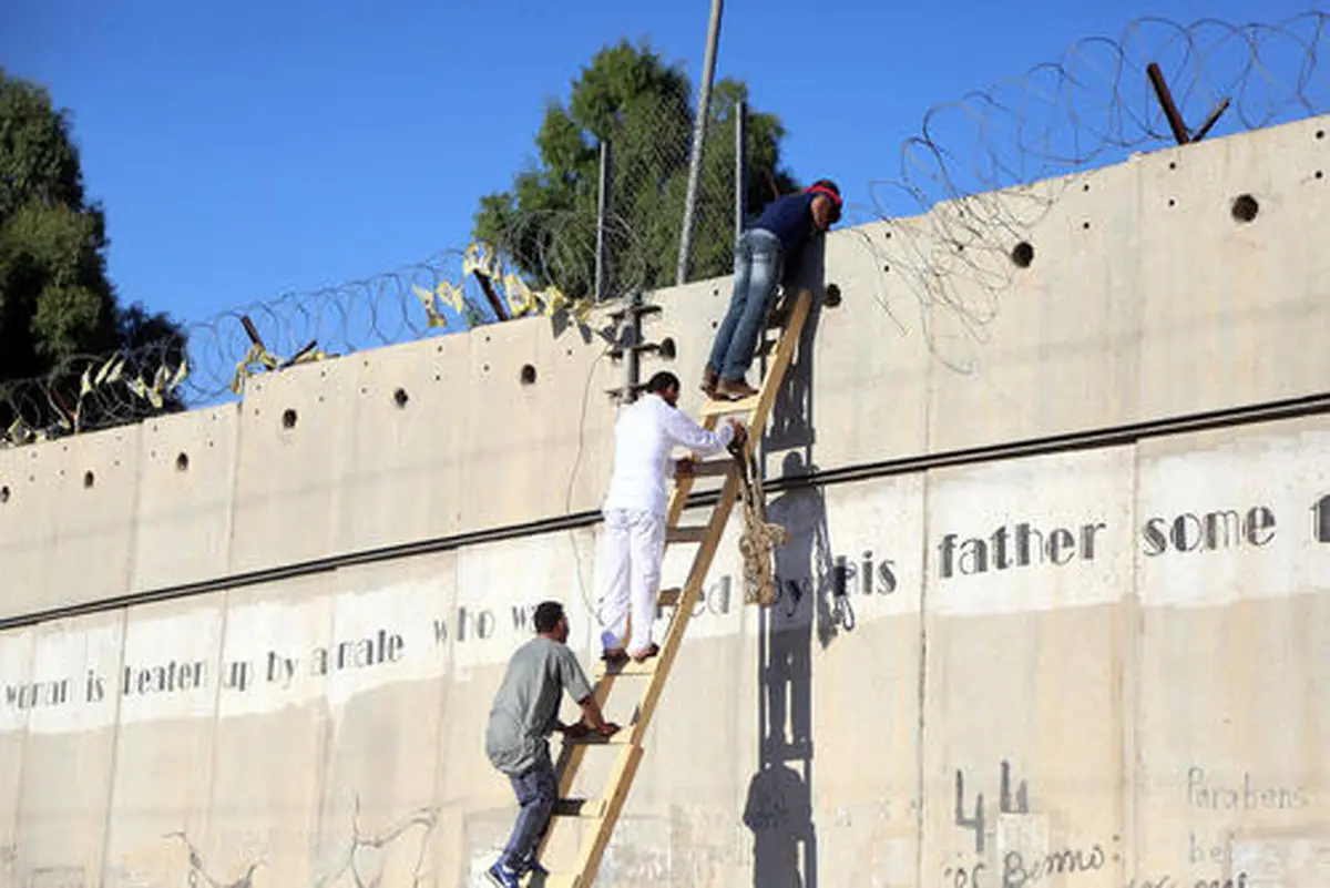 تلاش فلسطینی ها برای عبور از دیوار حائل اسراییل/عکس