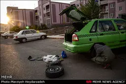 عکس/ تعویض لاستیک توسط راننده تاکسی زن