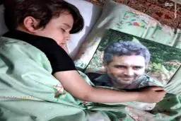 عکس:خواب آرام فرزند شهیدخدایی در کنار تصویر پدر