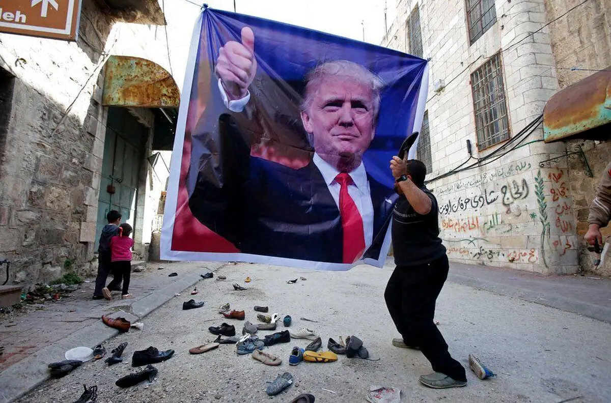 پرتاب کفش به عکس ترامپ در فلسطین/عکس