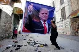 پرتاب کفش به عکس ترامپ در فلسطین/عکس