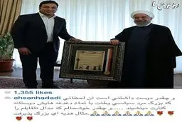 احسان حدادی در حال اهدای مدال ناقابل خود به رئیس جمهور/عکس