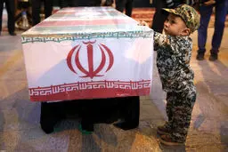 تصویری دردناک از فرزند شهید حججی در کنار تابوت پدر