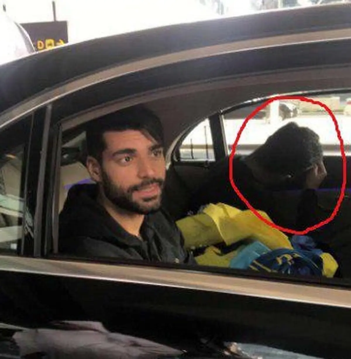 فردی که صورت خود را در کنار طارمی پوشانده بود کیست؟/ عکس