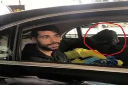 فردی که صورت خود را در کنار طارمی پوشانده بود کیست؟/ عکس