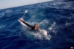 تصویری از شنای یک مهاجر غیرقانونی برای رسیدن به کشتی نجات در دریای مدیترانه