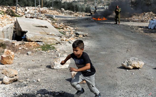 فرار یک کودک فلسطینی از دست سرباز اسرائیلی/عکس