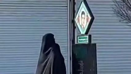 لحظه تاثر برانگیز یک مادر در خیابان مقابل تصویر فرزند شهیدش