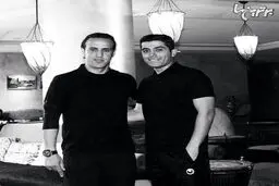 عکس سیاه و سفید علی کریمی در کنار مترجم کی‌روش