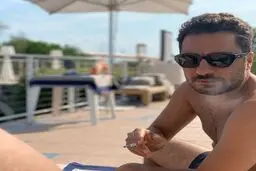 عکس برهنه نوید محمدزاده لب استخر مشغول سیگار کشیدن