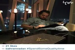 بهرام رادان در حال انتخاب غذا از منوی رستوران لوکس Vault در دبی با نمایی از برج العرب/عکس