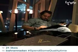 بهرام رادان در حال انتخاب غذا از منوی رستوران لوکس Vault در دبی با نمایی از برج العرب/عکس