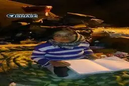 دختر کوچک زلزله‌زده‌ روی آوارها و در تاریکی درس می‌خواند/عکس