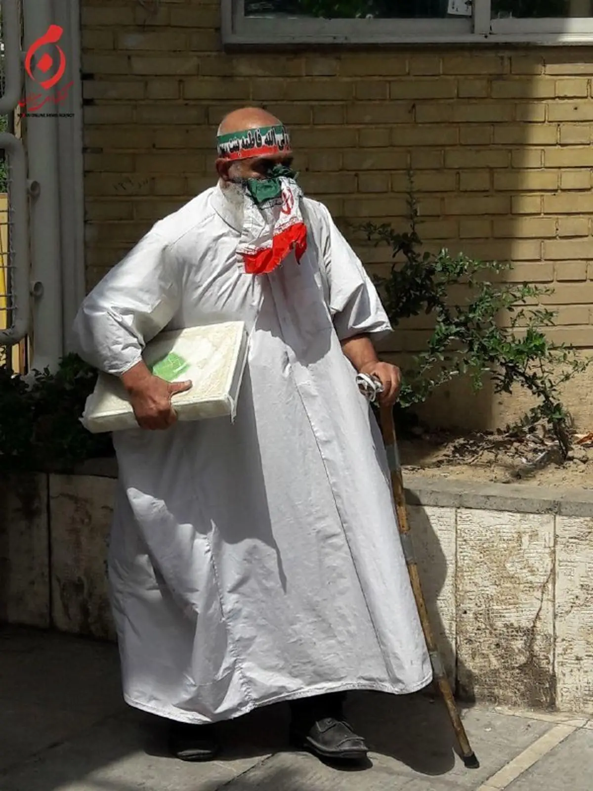 عکس:مرد کفن پوش با عصا و قرآن در ستاد انتخابات