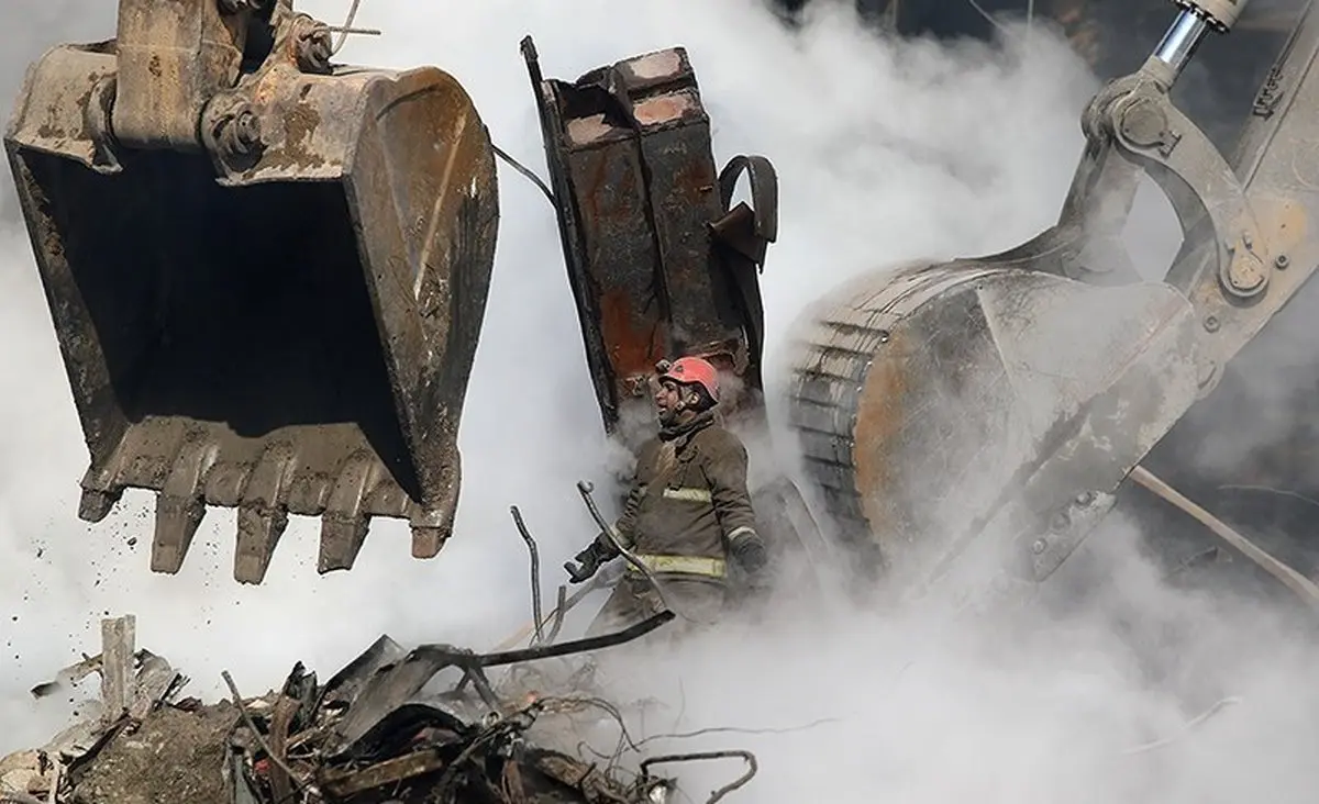 عکس / آتش‌نشان قهرمان در میان بیل‎های مکانیکی، دود و آتش
