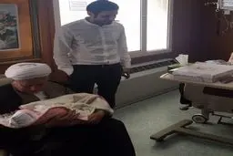 اذان گفتن آیت الله هاشمی در گوش یک نوزاد/ عکس