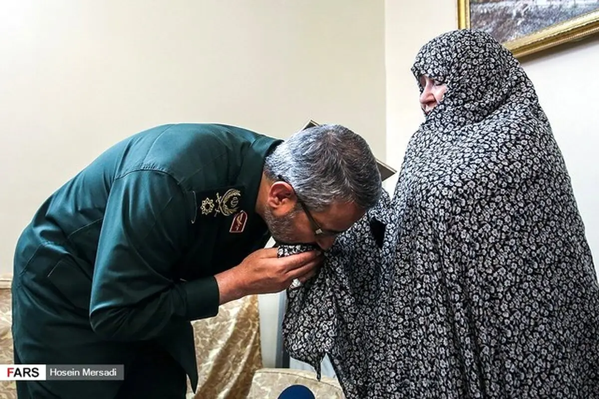 بوسه رئیس سازمان بسیج بر چادر یک مادر شهید/عکس